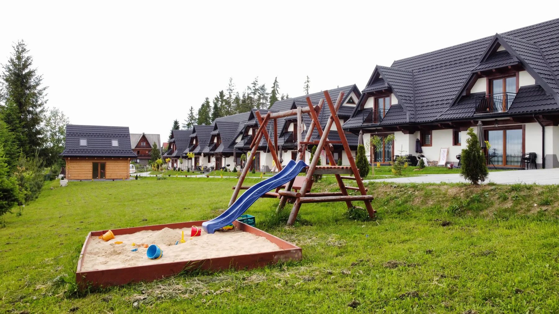 Plac zabaw na zielonym terenie przy domkach